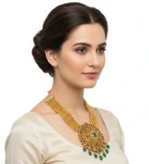 Gold necklace with green stones and ornate round pendant